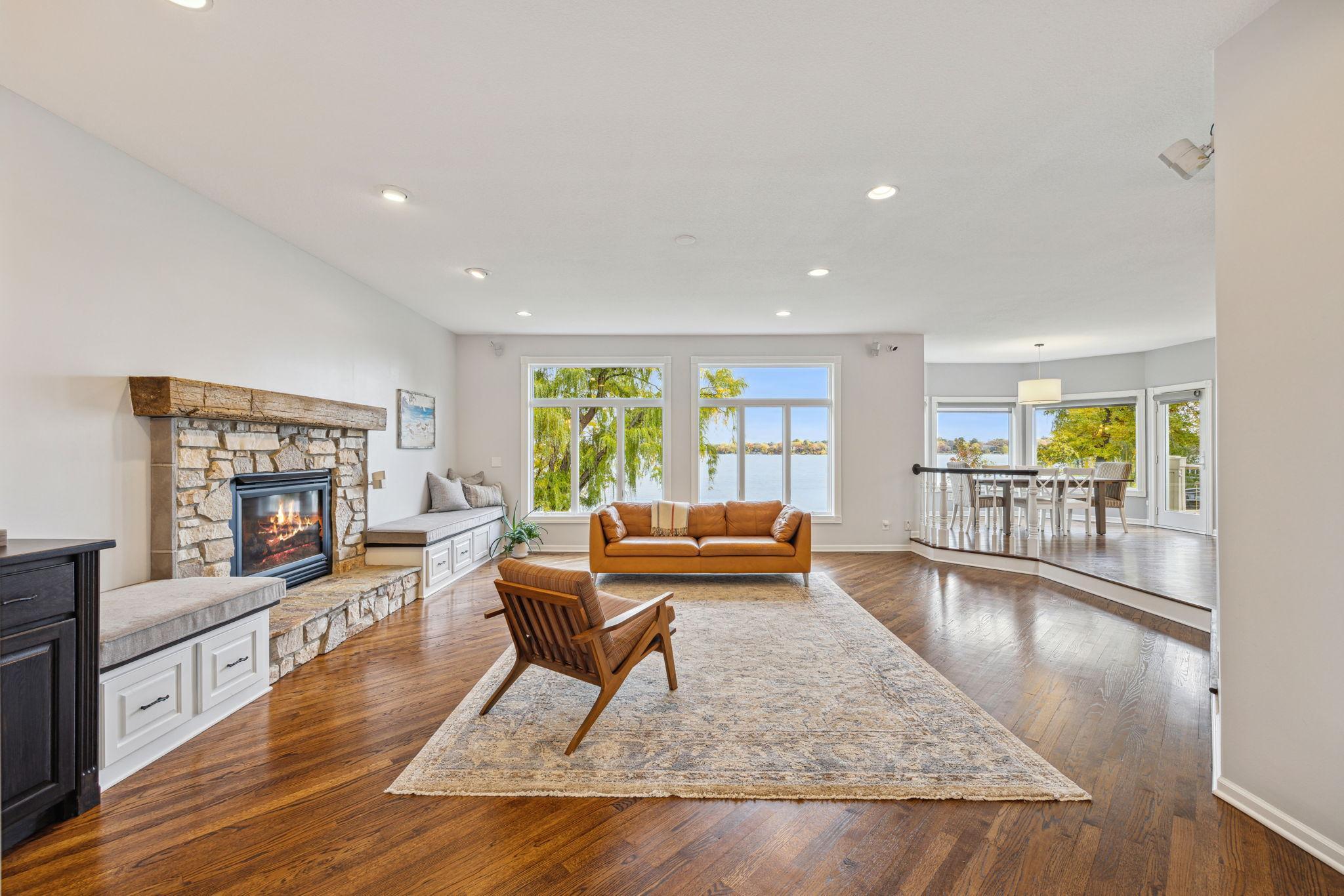 Family room has stone fireplace and wood floors and great views of the lake.