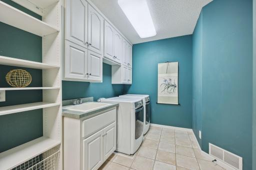 Large laundry just off the kitchen with extensive storage capacity.