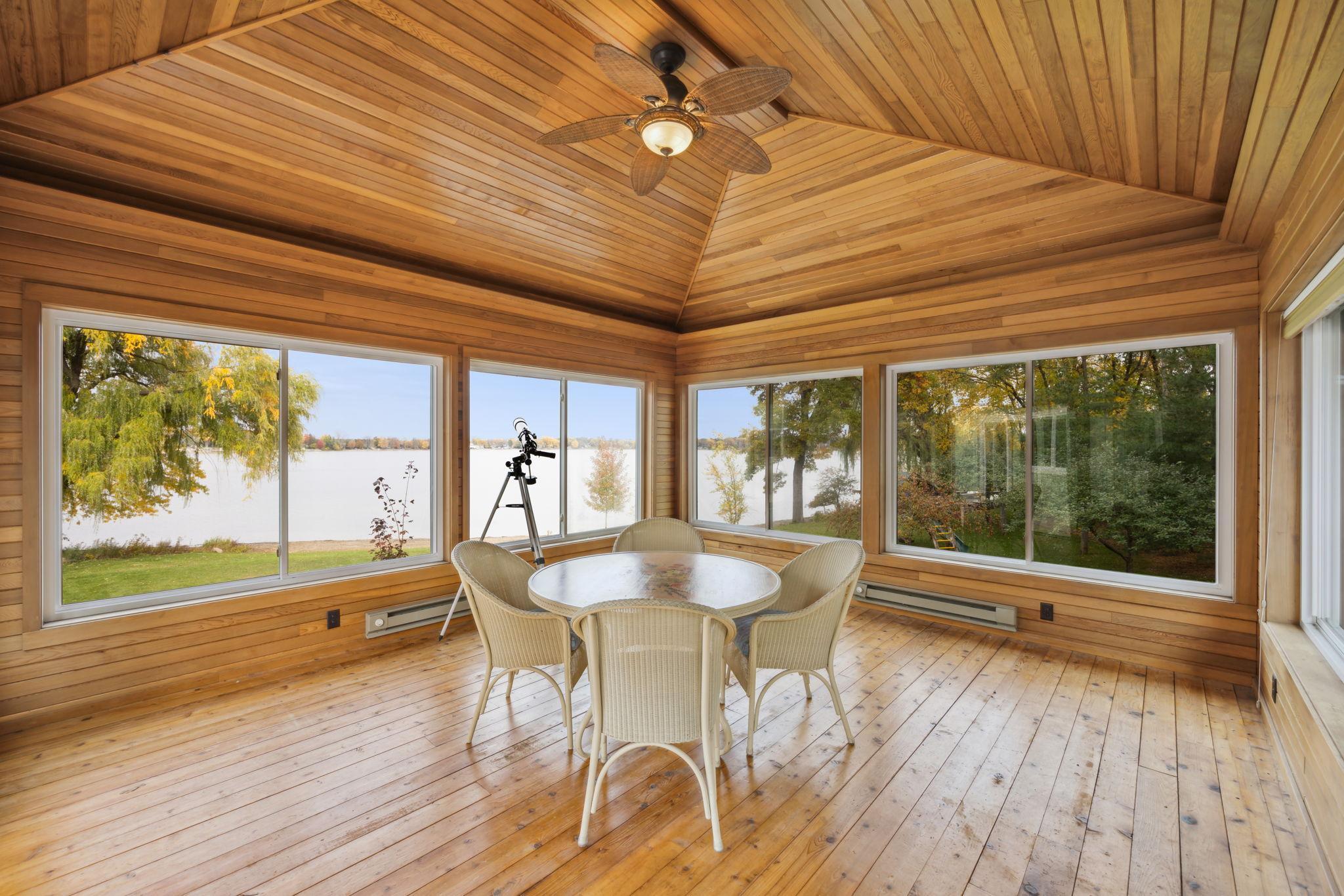 4 Season porch has wood ceilings and windows on all sides.