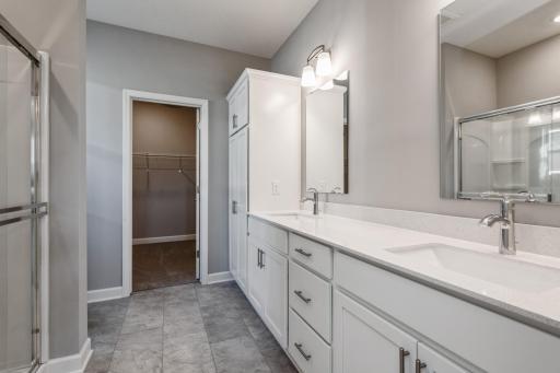 An extension of the owner's suite, this private and spacious bath contains a double-vanity, a large shower and a walk-in closet.