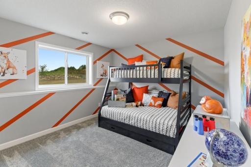 The second generously sized secondary bedroom with a spacious closet. (Photo of decorated model, actual home's finishes may vary slightly)