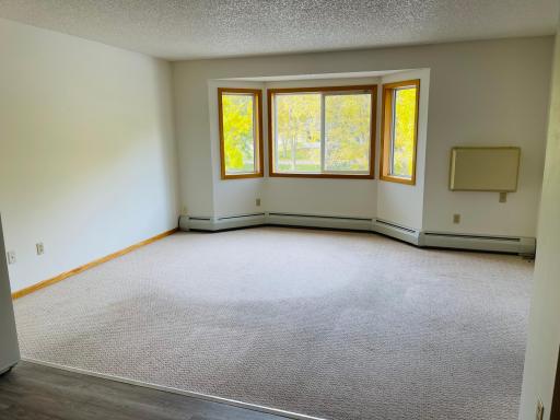 Living room in one bedroom apartment with bay window for lots of natural light!