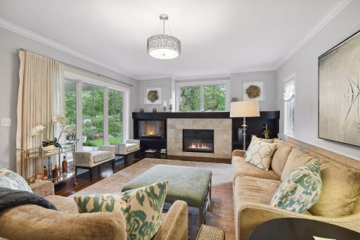 A living room to love! Oversized windows provide abundant natural light and views of Lake of the Isles from the front living room. Built-in cabinets surround the gas fireplace.