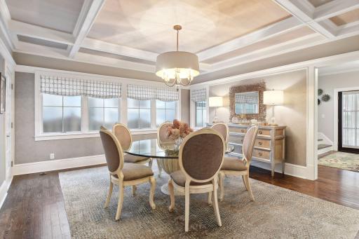 The formal dining room features box beam ceilings, wonderful natural light, beautiful hardwood floors, and designer finishes on every surface.