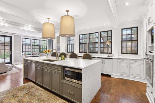 Large divided-light sash windows surrounding the kitchen provide glorious natural light, views, and fresh air. A back door leads to the stone patio.