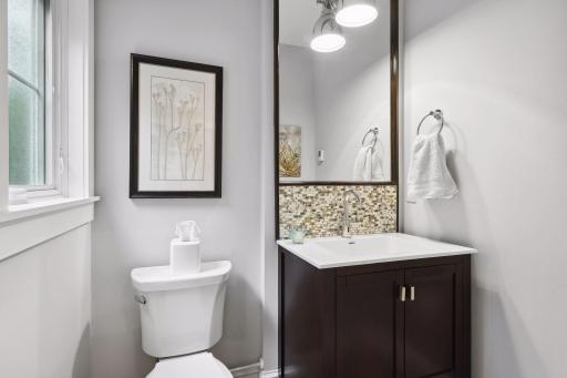 This main level powder room is discreetly located off of a back hall near the kitchen and mud room. A second powder room is located off of the front staircase landing near the primary living areas.