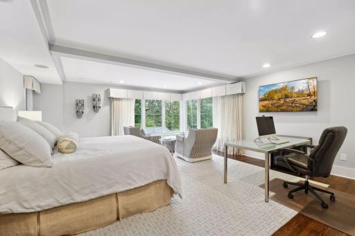 Dreamy primary suite with corner windows that maximize views of Lake of the Isles and the parkway from this upper level retreat.