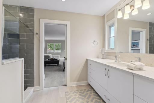 The Jack and Jill en suite bath features a designer tile walk-in shower, tile floors, and excellent counter space.