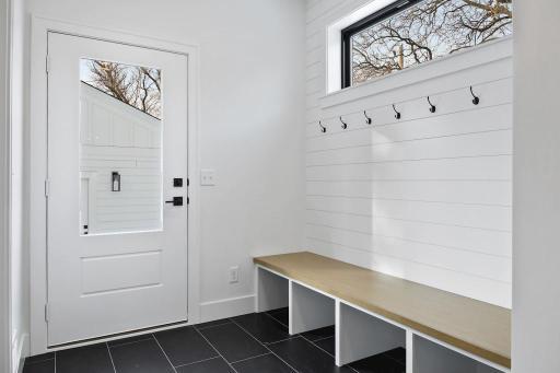 Rear mud room features bench, walk-in coat closet, and powder room. Pictures of previously built house.