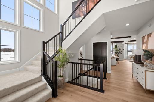 Talk about a wow factor! The impressive two-story foyer with full railed staircase, winds around the wall of windows allowing natural light to fill the area.