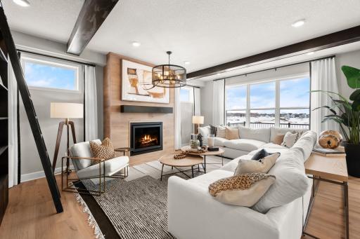 The warm and inviting family room is accented by beautiful wood beams and a gas fireplace with planked surround.