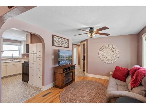 The living room features hardwood floors, tons of natural sunlight and a ceiling fan for added comfort.