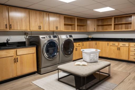 The main laundry has ample cabinet and counter space and upgraded appliances.