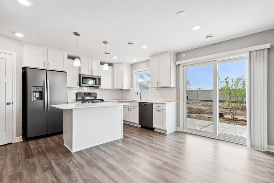 The Madison's open floorplan creates a great flow from kitchen to dining area. (Photo of a completed home, actual home's finishes may vary slightly)