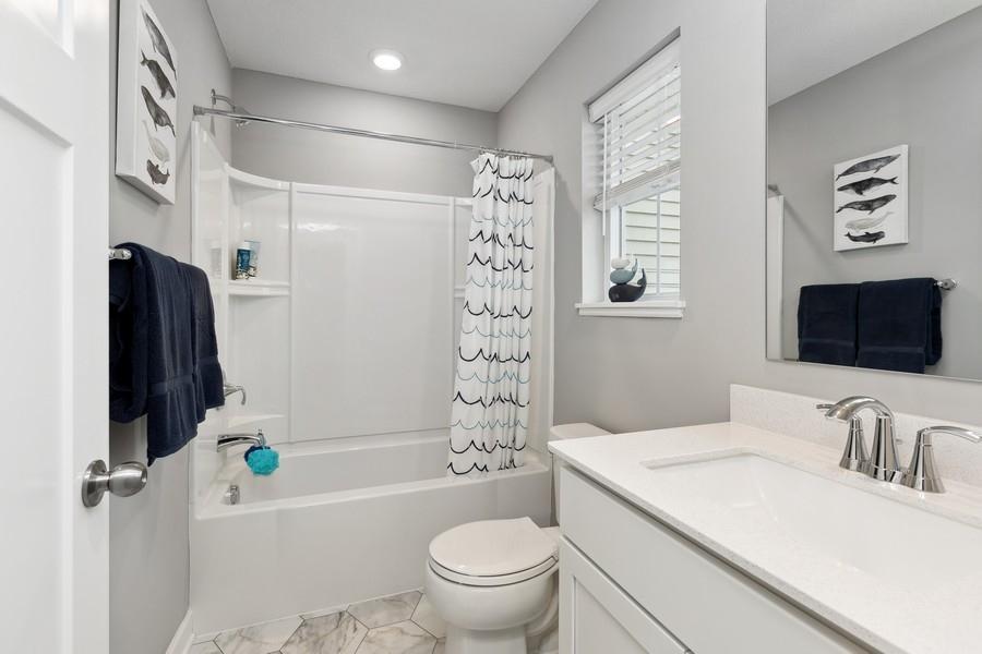 The stunning full bath is one of two baths located on the home's upper level. (Photo of decorated model, actual home's finishes may vary slightly)