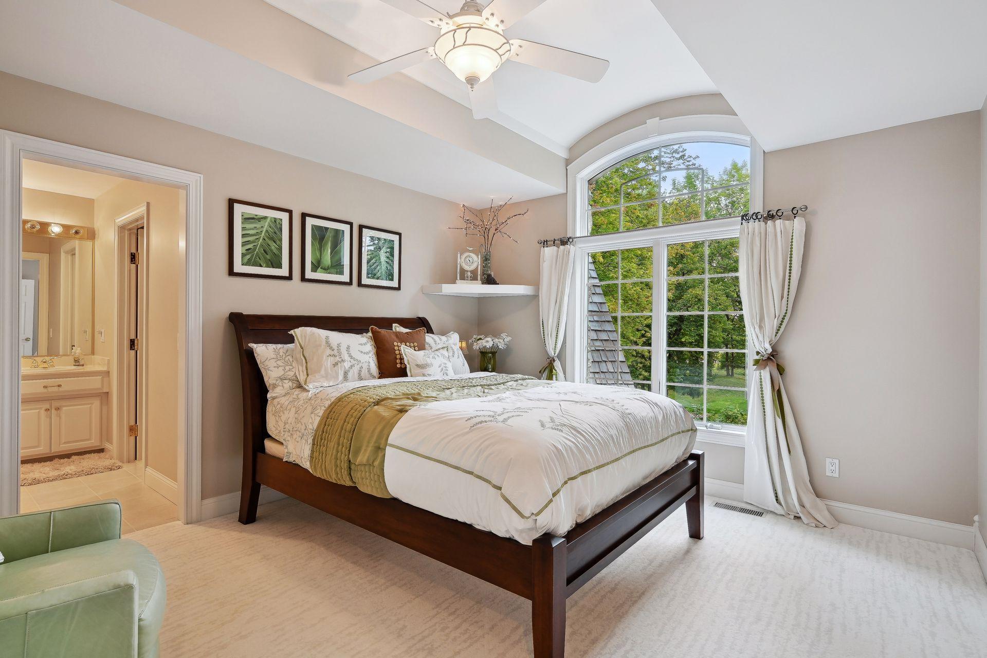 Bedroom #2 on Upper Level. French doors lead into this precious escape. The front-facing window is accentuated by the uniquely curved vault ceiling. Walk-in closet and private vanity.