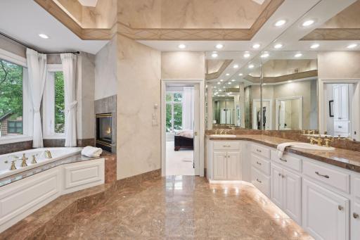 A spa-like escape to tranquility. Dim the lights and decompress in a deep bubble bath as the fire burns. Notice the beautiful architecture of the ceilings. Wonderfully lit with ample counter space. Glass door to walk-in marble shower. Private toilet.