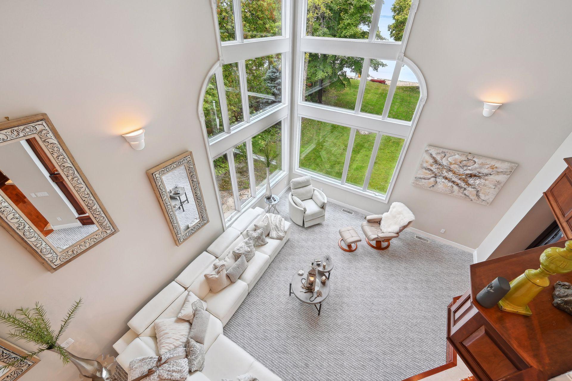Dramatic vantage point from the 2nd den/office, overlooking the main living room out to the lake. Floor to ceiling custom Anderson windows.