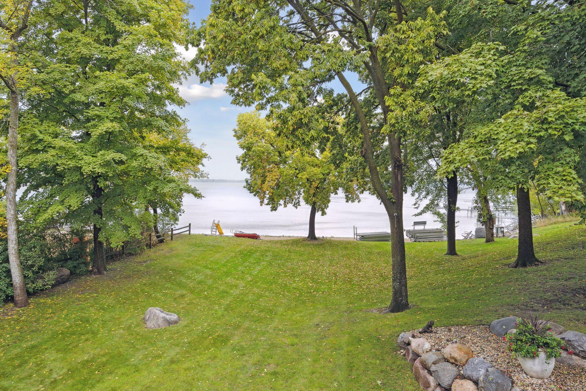 Sprawling, flat backyard stretches all the way to the water. Irrigated, lush lawn meets golden sandy beach.