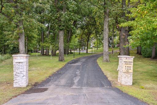 Customized pillars greet you at the entrance of the long private driveway. Lamps illuminate the way around the circular driveway to each of the three residences. Homes are nestled in the trees, far away from the curious eyes of traffic passing by.