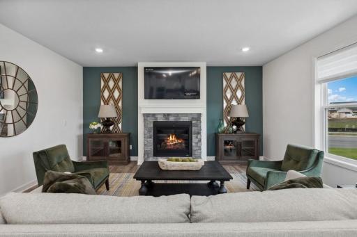 This modern fireplace with natural stone surround is an extraordinary room accent. Enjoy the warmth of this gas fireplace as you relax in your living room. (Photo of decorated model, actual home's finishes may vary slightly)