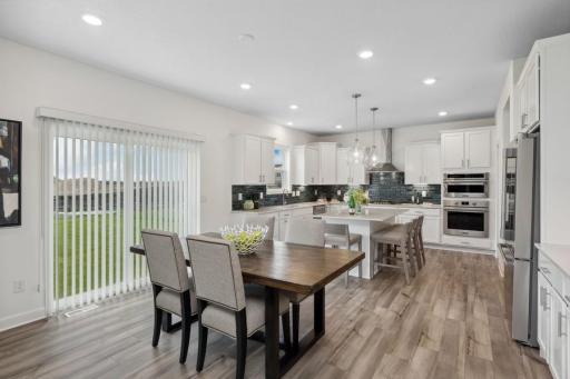 Soaked in natural sunlight, the homes eat-in dining room has ample space for a dining table located in the heart of the home. (Photo of decorated model, actual home's finishes may vary slightly)