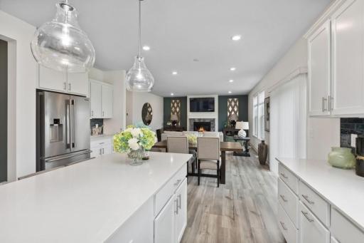 Enjoy plenty of seating at the kitchen island and dining area adjacent to the kitchen. Perfect for entertaining or having a family meal together. (Photo of decorated model, actual home's finishes may vary slightly)