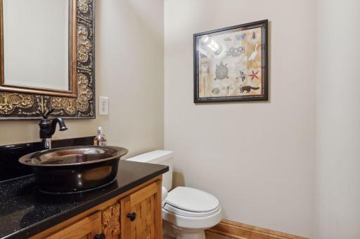 The main level 1/2 bath features a woven wood vanity and ceiling treatment!