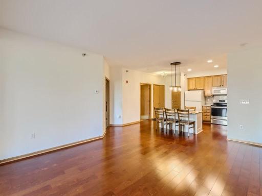 Living room with beautiful hardwood floors and open to the kitchen.