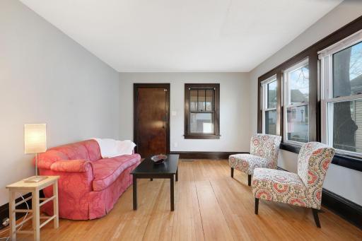 Drenched in original light, the living room features hardwood floors, tall ceilings and newer windows.
