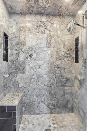 luxurious master marble tile shower with rain head