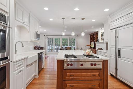 Kitchen adjacent to main floor family with sliding French double doors leading to a beautiful two tier deck and large backyard