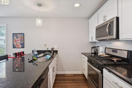 Gas stove, white cabinetry, granite counters