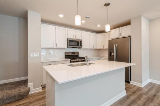 Stunning kitchen with stainless Slate appliances and white cabinetry brighten up the space. (Photos are not of actual home. Actual home will be similar. Some colors and features may vary.)