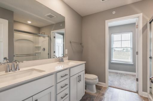 Private primary suite bathroom with double sink vanity and walk in shower! *Photos are of another home, colors and finishes may vary.