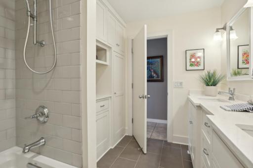 Ceramic floor, subway tiled tub/shower enclosure . Custom cabinetry including a linen closet and storage closet.