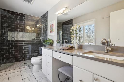 Exceptional primary bath. Double quartz topped sinks divided by vanity seating and spacious walkin ceramic tile shower.