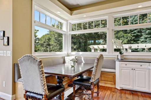 Lovely banquette area for informal dining. Tons of the storage in the drawers beneath the seating. Silhouette shades in the windows.