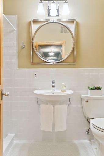 The upstairs 3/4 bath with penny tiled floors, subway surround and pencil detail.