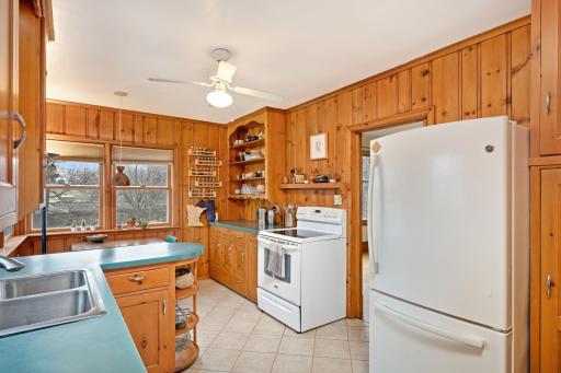 Walk into this inviting kitchen, where warmth and functionality meet, boasting a homey ambiance and abundant storage space to effortlessly accommodate both culinary essentials and cherished keepsakes.