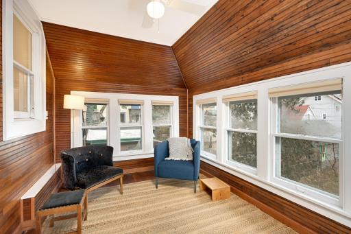 Bask in the beauty of the outdoors within the sunroom, where expansive windows offer views of the nearby park, and plenty of natural light too.