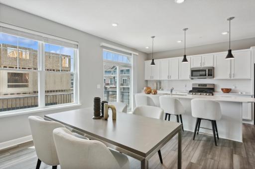 Enjoy plenty of seating at the kitchen island and dining area adjacent to the kitchen. (Photo of decorated model, actual home's finishes may vary slightly)