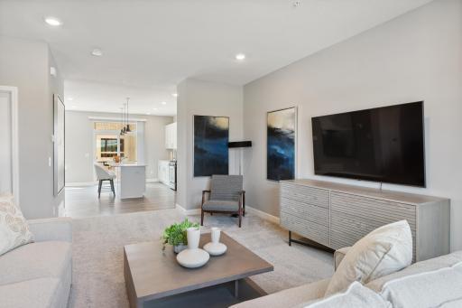 The main level seamlessly transitions from room to room while maintaining an open-concept layout throughout. (Photo of decorated model, actual home's finishes may vary slightly)
