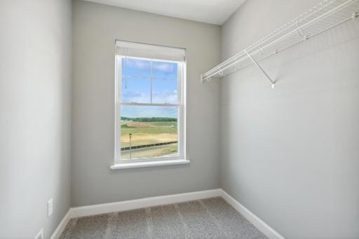 The owner's suite includes an incredible walk-in closet. Plus, notice the wonderful closet window, a perfect way to brighten up every day. (Photo of a completed home, actual home's finishes may vary slightly)