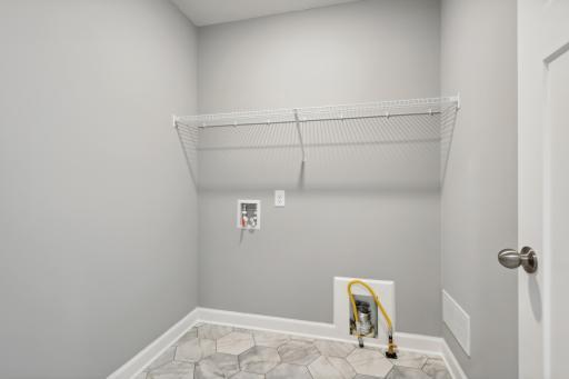 Centrally located on the upper level, along with the three bedrooms, this laundry room is sure to provide the ultimate convenience. (Photo of a completed home, actual home's finishes may vary slightly)