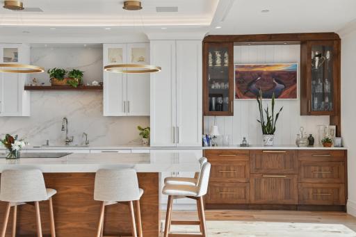 The masterly crafted walnut bar with 2 refrigeration drawers is a conversation starter. It's unique blend of material and hardware elevates this space to art!