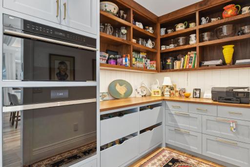 The pantry is equipped with a Wolf 30" oven and a Wolf 30" microwave. Pull out drawers, custom cabinets and walnut shelving contribute to the functionality of this coveted space.