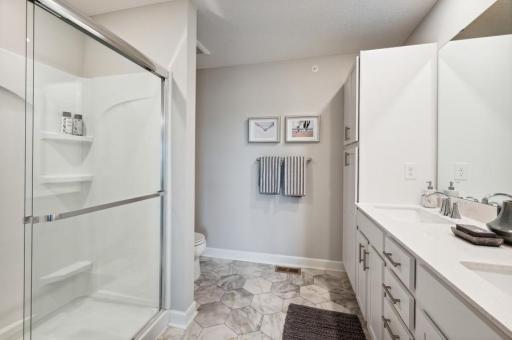 An extension of the owner's suite, this private and spacious bath contains a double vanity and a separate shower. (Photo of decorated model, actual home's finishes may vary slightly)