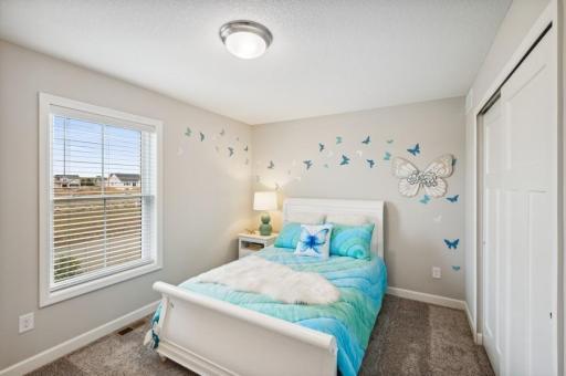 Each of the home's secondary bedrooms come perfectly sized and all feature a spacious closet. (Photo of decorated model, actual home's finishes may vary slightly)