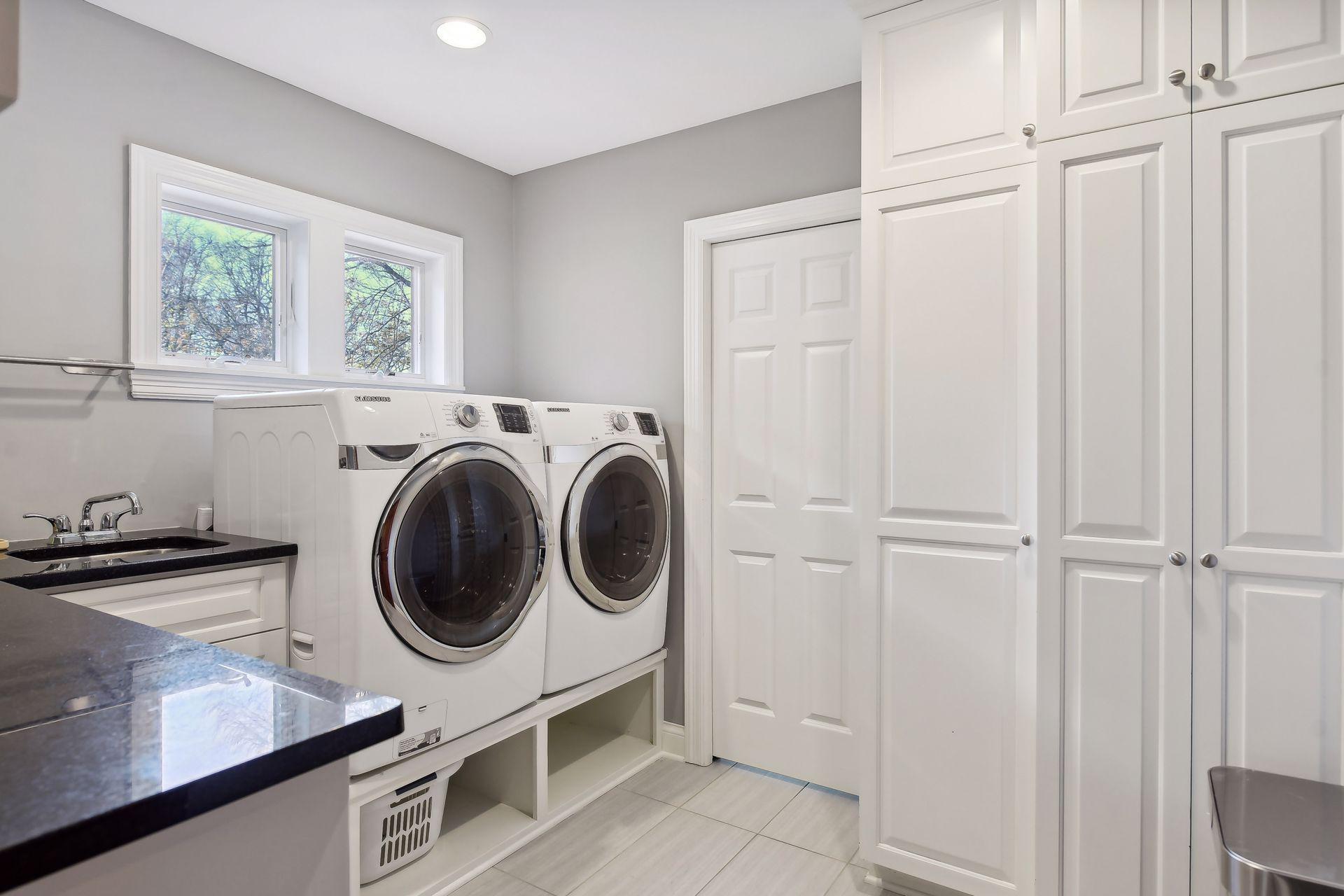 Upper-level laundry room with ample storage.